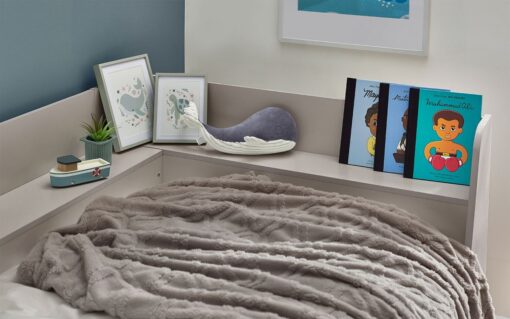 The inbuilt shelf around the mattress of the Cyclone Day Bed in Taupe from Pay Weekly Carpets, with a small plush toy, some children's books and photo frames helping show the depth of shelf and size of objects that can be placed upon it